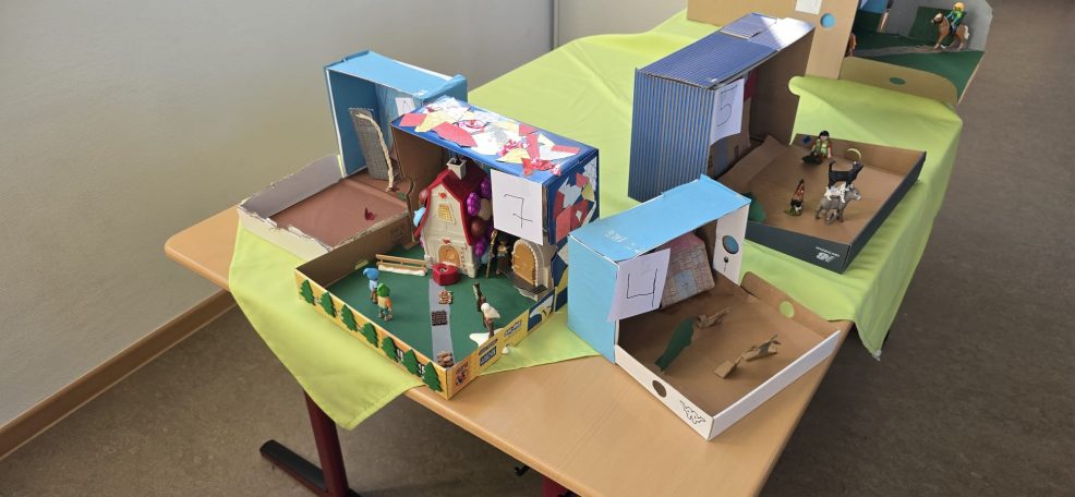 Bastelarbeiten in Schuhkartons, die verschiedene Themen und Szenen darstellen.