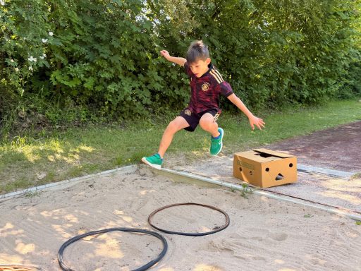 Junge sprigt in Reifen in einer Sandgrube